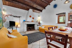 a living room with yellow furniture and a fireplace at Stazzu Straetu in Olbia