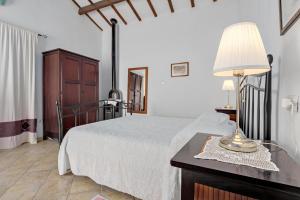 een slaapkamer met een bed en een tafel met een lamp bij Stazzu Straetu in Olbia