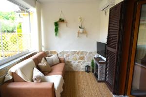 ein Wohnzimmer mit einem Sofa und einem TV in der Unterkunft JANNUZZI HOUSE in Trevignano Romano