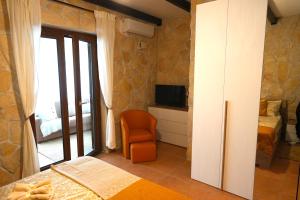 a bedroom with a bed and a chair and a television at JANNUZZI HOUSE in Trevignano Romano