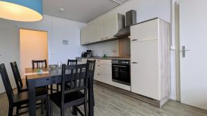eine Küche mit einem Tisch und einem weißen Kühlschrank in der Unterkunft GWG City Apartments III in Halle-Neustadt
