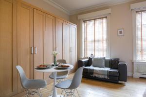 a living room with a table and chairs and a couch at Small sun lit studio minutes from Kings Cross station in London