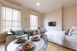 a living room with a bed and a table with food at Small sun lit studio minutes from Kings Cross station in London
