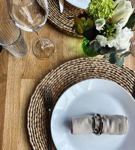 una mesa con una placa blanca con un cuchillo y un tenedor en Maison d'Hôtes "Les Bulles Dorées" en Rilly-la-Montagne