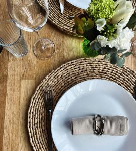 a table with a white plate with a knife and fork at Maison d'Hôtes "Les Bulles Dorées" in Rilly-la-Montagne