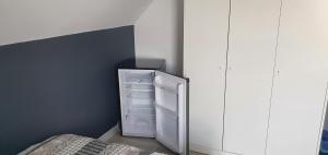 a small kitchen with an empty refrigerator in a room at Apartamenty i pokoje TT Mielno ALLDAYHOLIDAY in Mielno
