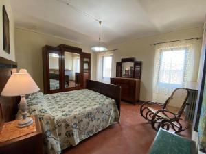 パニカーレにあるAntica Casa dei Fratiのベッドルーム(ベッド1台、ランプ、椅子付)