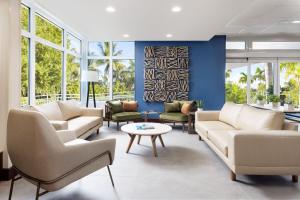 a living room with couches and tables and windows at Fairfield Inn & Suites by Marriott Key West at The Keys Collection in Key West