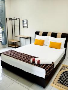 a bedroom with a large bed with orange and white pillows at Mukmin 2 Stay in Melaka