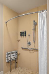 a shower with a shower curtain in a bathroom at Four Points by Sheraton Chicago Westchester/Oak Brook in Westchester