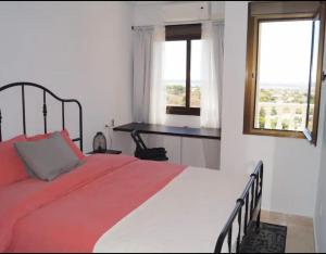ロハレスにあるAcogedor apartamento con vistasのベッドルーム1室(赤い毛布、窓2つ付)