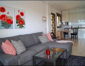 ロハレスにあるAcogedor apartamento con vistasのリビングルーム(グレーのソファ、テーブル付)
