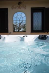 La salle de bains est pourvue d'une baignoire remplie d'eau bleue. dans l'établissement Natuscia Country Villa - Private Jacuzzi - Garden, à Ronciglione
