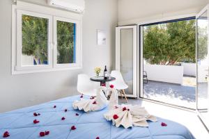 a bedroom with a blue bed with roses on it at Aegean Blue Santorini Perissa in Perissa