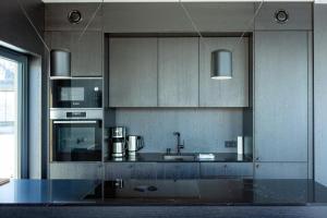 a kitchen with a sink and a stove top oven at Lyngvær Arctic Pearl Lodge - Jacuzzi & Sauna - No 17 in Kleppstad