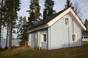 ein kleines weißes Haus mit einem Gameradach in der Unterkunft Lossisaari Tourist Center in Keitele