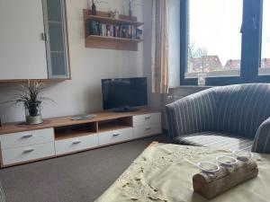 ein Wohnzimmer mit einem Sofa und einem TV in der Unterkunft Ferienhaus Heyder in Norderney