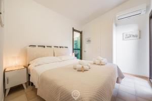 um quarto branco com 2 camas e toalhas em Villa Katia - Near the Beach em Simius