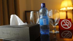 a bottle of water sitting on a table with glasses at Wassamar Hotel in Addis Ababa