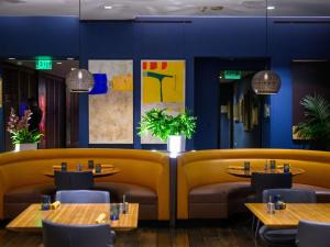 a restaurant with tables and chairs and blue walls at Hotel Sofitel Los Angeles at Beverly Hills in Los Angeles