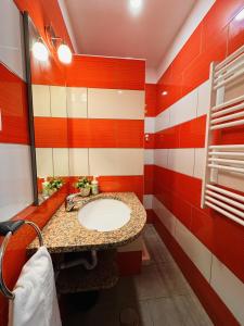 - une salle de bains rouge et blanche avec lavabo et miroir dans l'établissement Casa Luz Apartamento 2, 