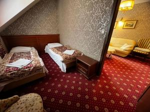 a hotel room with two beds and a chair at Hotelik Orański in Stronie Śląskie