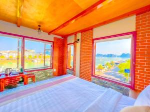 1 dormitorio con 1 cama y ventanas grandes en Cánh Buồm Homestay - Tuần Châu, en Ha Long