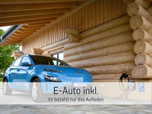 um carro azul estacionado em frente a um edifício em Natur-Chalet zum Nationalpark Franz inkl. E-Auto em Allenbach