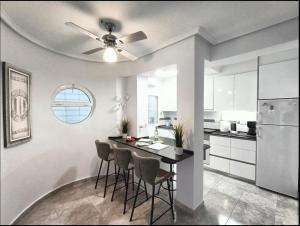 a kitchen with a table with chairs and a ceiling fan at R-15 Rincón del Sol in Torrevieja
