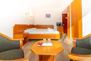 Zimmer mit einem Bett, 2 Stühlen und einem Tisch in der Unterkunft Villa Caprice in Constanţa
