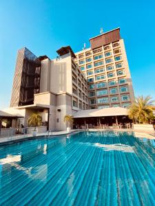 a large swimming pool in front of a hotel at The Landmark Towers in Kānpur