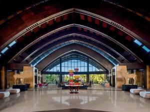 eine Lobby mit einem großen Gebäude mit einem großen Fenster in der Unterkunft Pullman Oceanview Sanya Bay Resort & Spa in Sanya