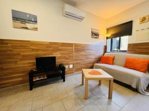 een woonkamer met een bank en een tv bij Casa Luz Apartamento 3 