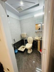 a bathroom with a toilet and a sink at Moven Inn Hotel Islamabad in Islamabad