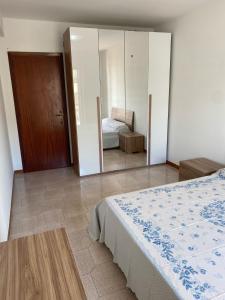 1 dormitorio con cama y espejo en LA FINESTRA SUL MARE, en Ali Terme