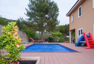 a swimming pool with a slide and a playground at Villa Sitges Mas Mestre in Olivella