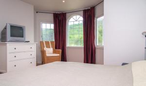 a bedroom with a bed and a tv and a chair at Villa Sitges Mas Mestre in Viladellops +27 photos