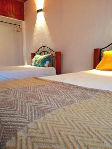 two beds in a hotel room with two beds at Indovu Back Packers in Nairobi