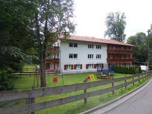 un edificio con parque infantil frente a una casa en Haus Am Mühlbach - SommerBergBahn unlimited kostenlos, en Oberstdorf
