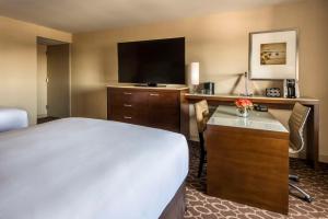 a hotel room with a bed and a flat screen tv at Hyatt Regency O'Hare Chicago in Rosemont
