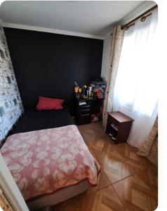 - une chambre avec un lit et un mur noir dans l'établissement Casa aislada 1 piso Peñaflor-Malloco, à Talagante