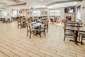 uma sala de jantar com mesas e cadeiras e uma lareira em Best Western Port Columbus em Columbus