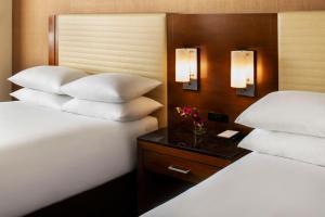 two beds in a hotel room with white pillows at Hyatt Regency O'Hare Chicago in Rosemont