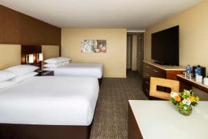 a hotel room with two beds and a flat screen tv at Hyatt Regency O'Hare Chicago in Rosemont
