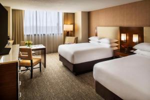 a hotel room with two beds and a desk at Hyatt Regency O'Hare Chicago in Rosemont