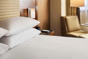 a hotel room with a bed and a chair at Hyatt Regency O'Hare Chicago in Rosemont