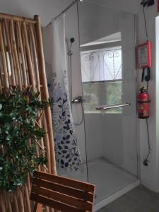 uma porta de duche em vidro num quarto com um banco em House Village ** em São Bartolomeu de Messines