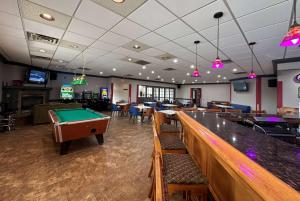 a bar with a pool table in a casino at Ramada by Wyndham Waupaca in Waupaca