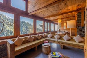 un soggiorno con un grande divano e finestre di Elivaas Skyline Luxury 4BHK Entire Home in Narkanda a Shimla