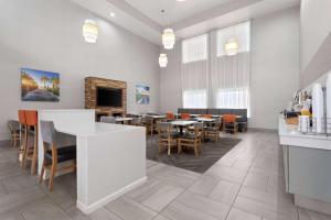 a dining room with tables and chairs and a fireplace at La Quinta by Wyndham Ft. Pierce in Fort Pierce